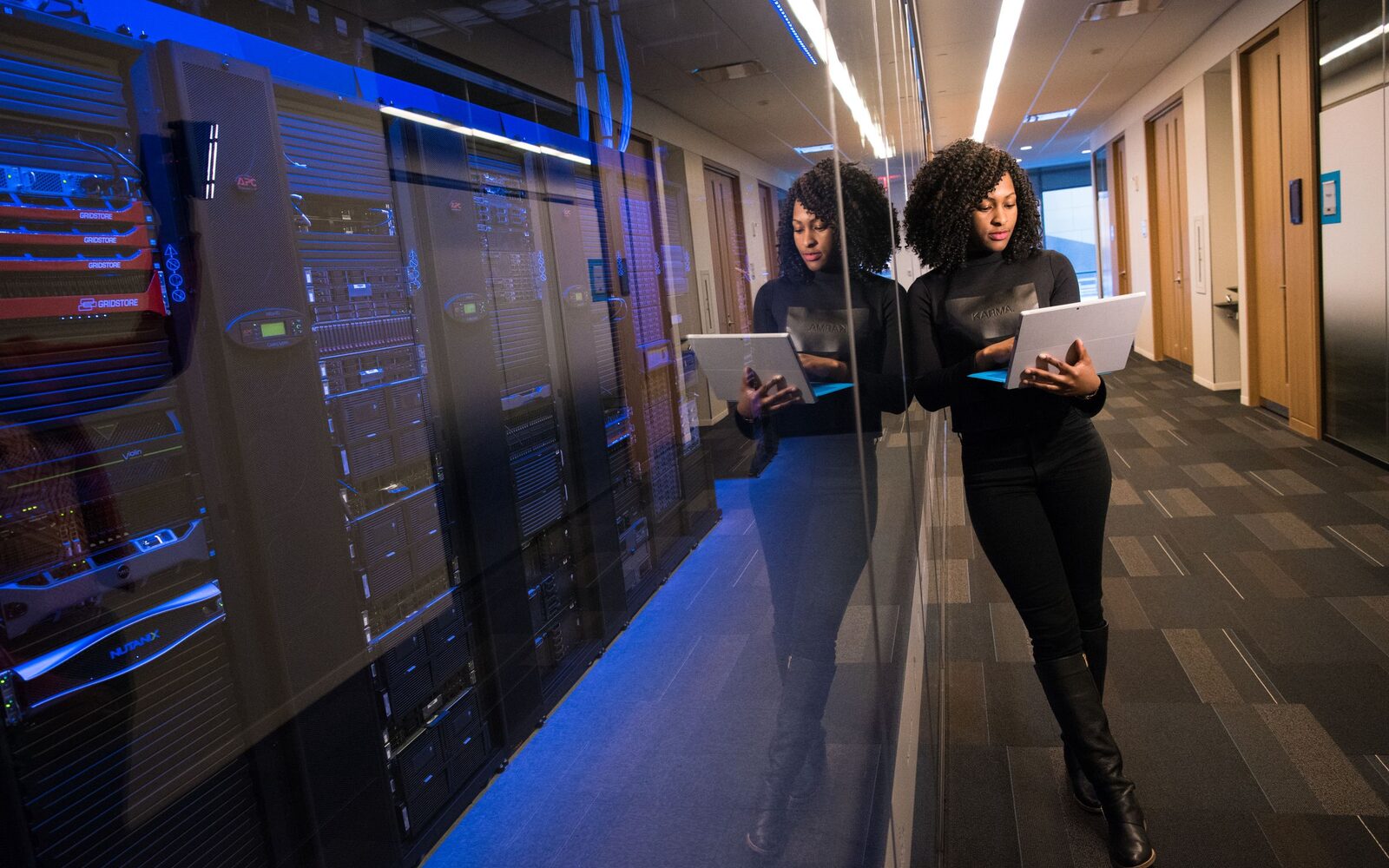 An engineer walking a server aisle with a laptop open