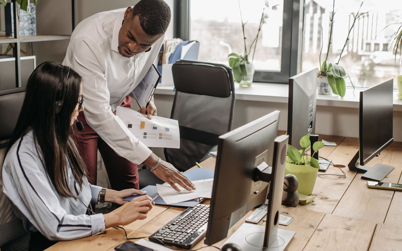 An engineer helping a colleague at their desk