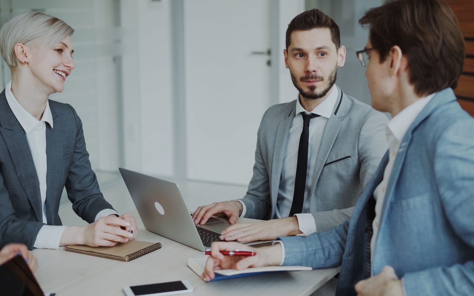 A small group meeting around a laptop in an office