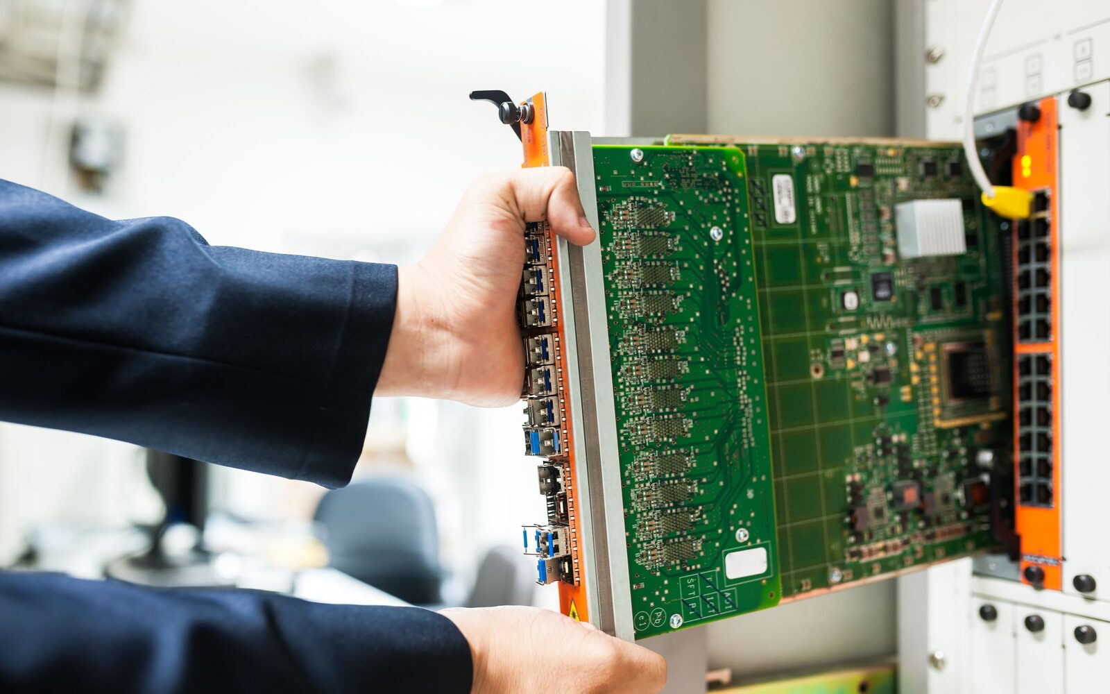 Hands seating a line card into a core network switch