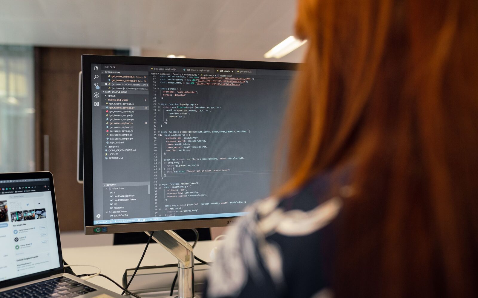 An engineer reading through code on a large monitor