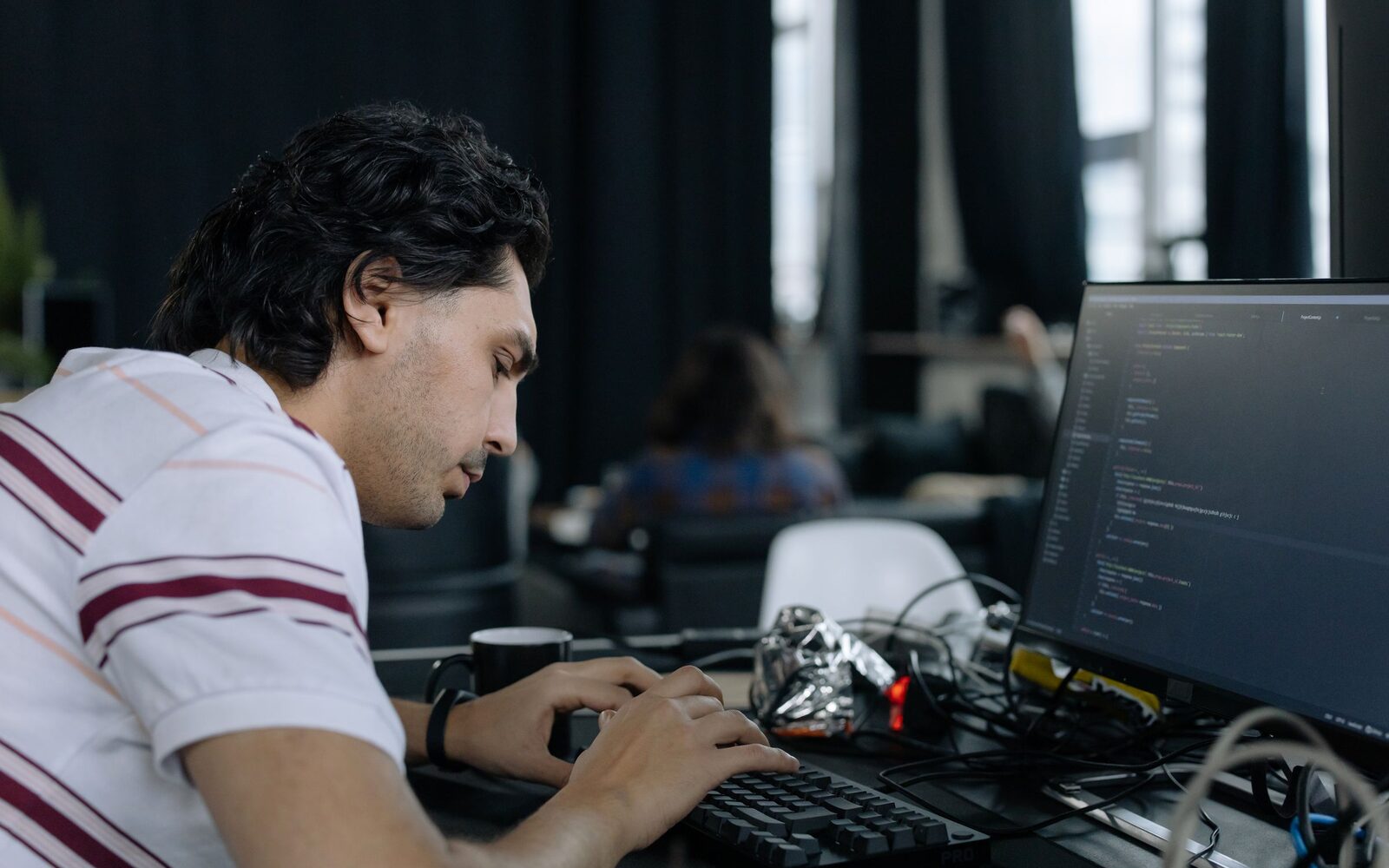 A developer at a working desk with hardware and a monitor