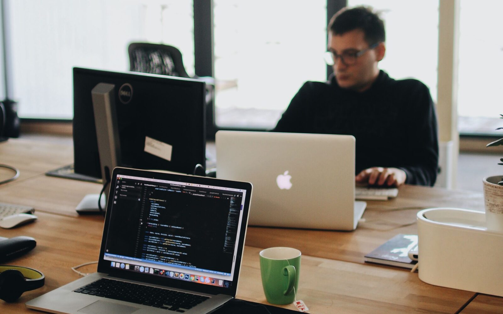 A studio office with laptops along a shared desk